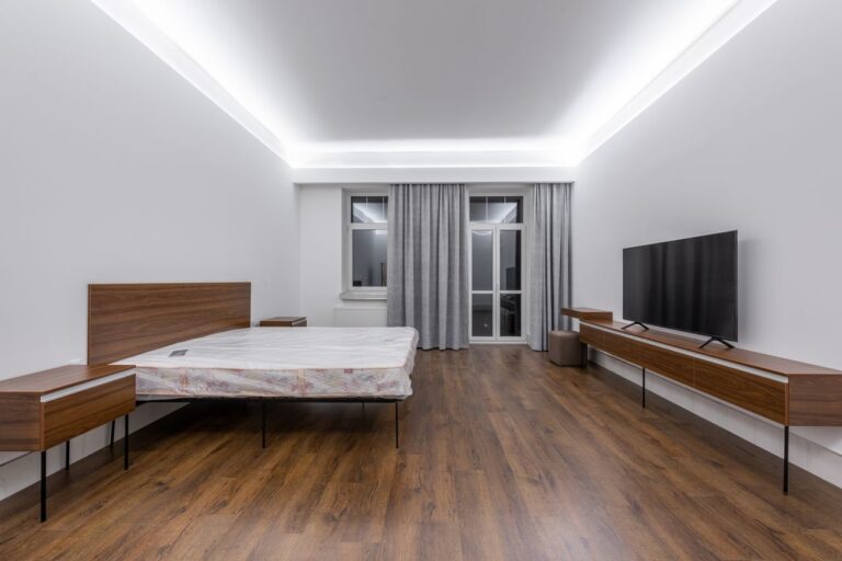 Spacious, minimalist bedroom with a wooden floor and modern design elements